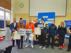 Na zdjęciu czterech mężczyzn w strojach cywilnych, trzech z nich trzyma w ręku dyplom, dwóch policjantów oraz kobieta  w stroju cwywilnym. W tle banery.