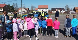 Policjanci pokazują przedszkolakom oznakowany radiowóz