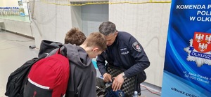 Policjant ruchu drogowego prezentuje sprzęt wykorzystywany w służbie