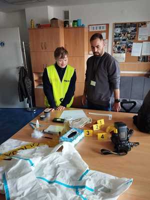 Nieumundurowany f-sz KPP Chrzanów zapoznaje słuchacza z wyposażeniem technika krym