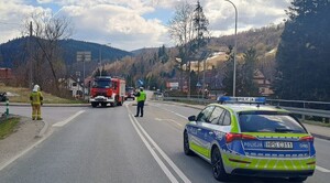 policjant na skrzyżowaniu kieruje ruchem i wskazuje drogę wozon strażackim