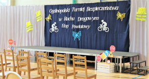 Tablica z napisem Ogólnopolski Turniej Bezpieczeńśtwa w Ruchu Drogowym etap powiatowy, krzesła oraz znaki drogowe w skrzynce