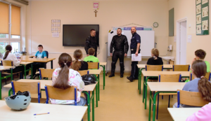 Umundurowani policjanci oraz uczniowie biorący udział w częsci teoretycznej konkursu