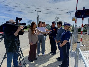 Na przejeździe kolejowym dziennikarze prowadzą wywiad z policjantką oraz dwoma mężczyznami