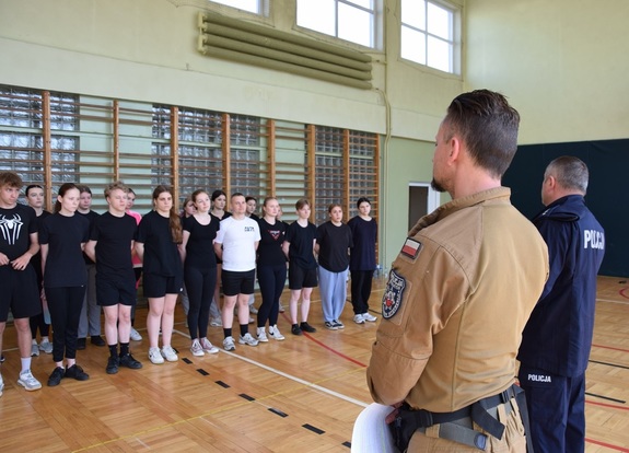 Klasa mundurowa w sali gimnastycznej przed instruktorami Policji