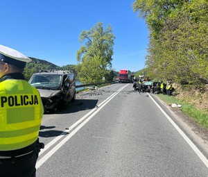 uszkodzone w wyniku zderzenia pojazdy, obok policjanci wykonujący oględziny
