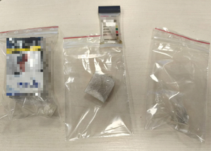 Trzy woreczki strunowe wewmątrz których są środki odurzające w postaci białych kryształków, w jednym jest pudełko po papierosach. Nad środkowym woreczkiem jest narkotest.