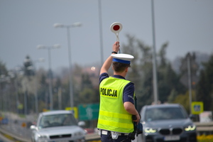 Policjant ruchu drogowego zatrzymujący pojazd do kontroli drogowej