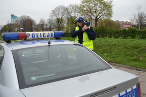 Policjant ruchu drogowego mierzy prędkość pojazdów