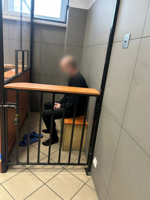 zatrzymany w pomieszczeniu dla osób zatrzymanych przebiera się