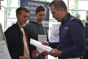 Policjant wręcza dyplom zawodnikowi
