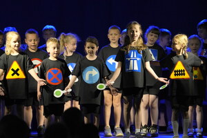 klasa na scenie tańczy w rytm muzyki w podkoszulkach z wydrukowanymi znakami drogowymi - zbliżenie