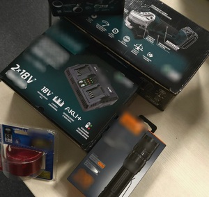 Odzyskane elektronarzędzia w tym ładowaka, szlifierka i latarka. Przedmioty są w pudełkach.