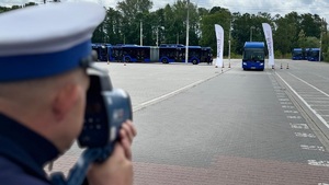 policjant mierzy prędkość autobusu prowadzonego przez uczestnika turnieju