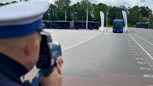 policjant mierzy prędkość autobusu prowadzonego przez uczestnika turnieju