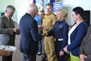 Prezes PZM wręcza policjantce odznakę