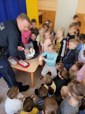 policjant uczy dzieci jak prawidłowo opatrywać rany