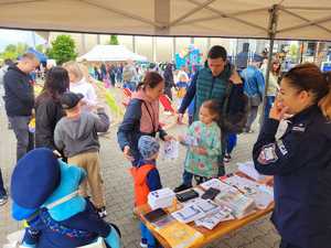 Uczestnicy pikniku przy stanowisku policji z policjantką.