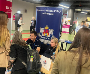 Policjanci rozmawiają z zainteresowanymi na targach pracy.