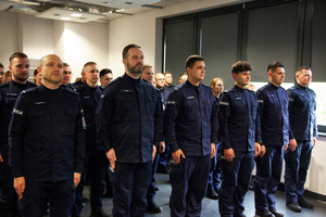 Policjanci kończący kurs podoficerski stoją na sali.