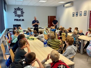 Policjant mówi dziecom o bezpieczeństwie na drodze.