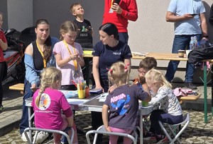 Policjantka przy stoisku z dziećmi.