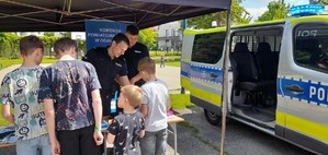 Policjanci rozmawiają z dziećmi na stoisku policyjnym.