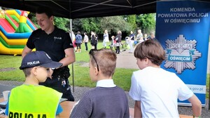 Policjant rozmawia z dziećmi na pikniku.