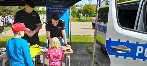 Policjanci rozmawiają z dziećmi na stoisku policyjnym.