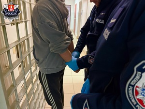 policjant zakuwający kajdanki zatrzymanemu w pdoz