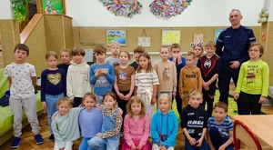 Pamiątkowe zdjęcie grupy dzieci z policjantem.