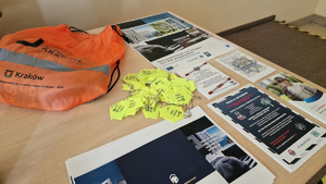 Leżące na stole ulotki, broszury, plakaty, odblaski przeznaczone dla uczestników prelekcji