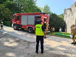 umundurowany policjant i wóz strażacki