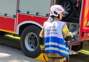 umundurowany strażak i wóz strażacki