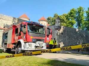 wóz strażacki, w tle umundurowani policjanci