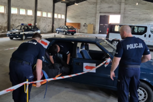 działania ratownicze, ratownicy przechodzą przez pojazd z noszami