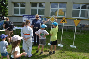 Policjantka pokazuje dzieciom znak drogowy