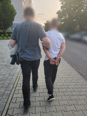 policjant prowadzi zatrzymanego