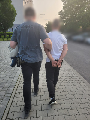 policjant prowadzi zatrzymanego