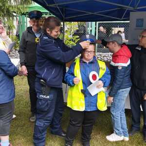 umundurowana policjantka z oglądającymi stoisko policyjne