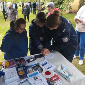 umundurowana policjantka z osobami oglądającymi policyjne gadżety