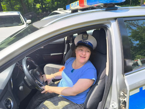 Dziewczynka siedząca za kierownicą policyjnego radiowozu