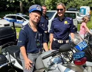 Policjantka stoi obok chłopca ubranego w policyjny strój