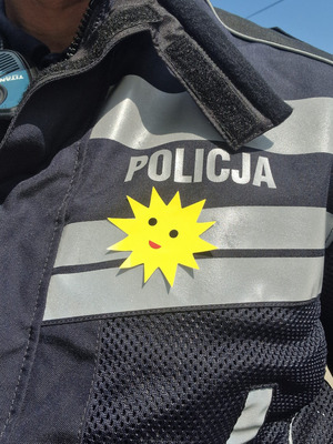 Sloneczko nalepione na policyjną kamizelkę