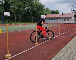 Dziewczynka na rowerze omija pachołki