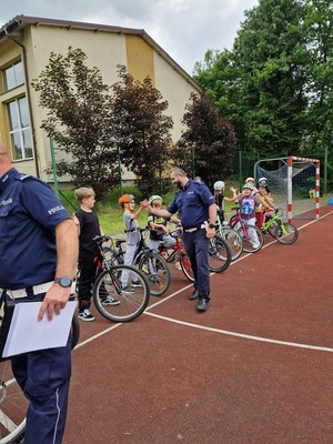 policjanci przybijający piątki uczestnikom egzaminu