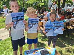 dzieci wraz z plalatami Letni przewodnik