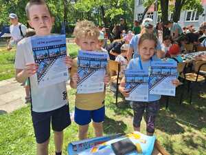 dzieci wraz z plalatami Letni przewodnik