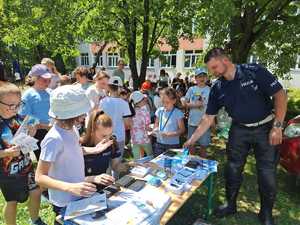 policjanci z uczniami przy stanowisku policyjnym