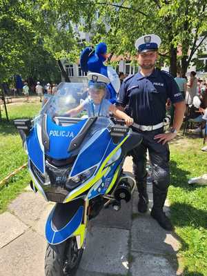 policjant wraz z uczniem siedzącym na motocyklu